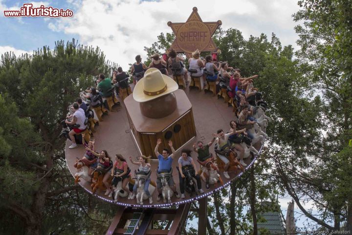 Immagine Il disco coaster di Buffalo Bill Rodeo a Mirabilandia, Emilia Romagna, Italia. A mezza via tra un tagadà e una montgna russa, questa nuova attrazione simula un rodeo con 24 passeggeri seduti su un cavallo disposti sulla circonferenza di un disco rotante che fa 14 giri al minuto andando avanti e indietro su un binario lungo 80 metri a forma di W allungata. Ci si può arrampicare sino a 13 metri di altezza con un'angolazione di 90 gradi rispetto al terreno.