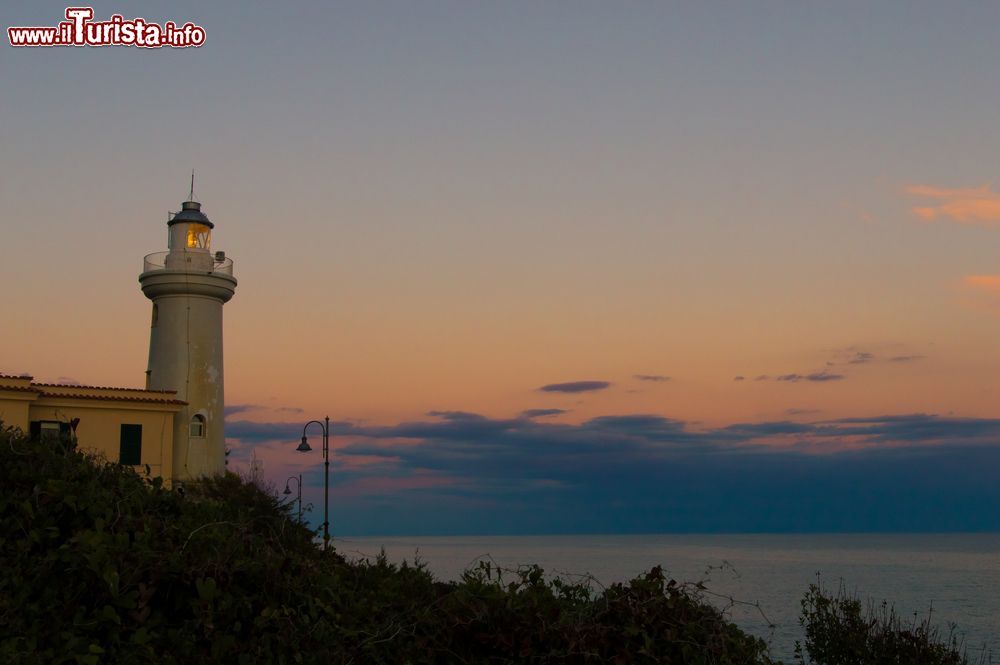 Immagine Il faro di San Felice Circeo, Lazio, visto al tramonto. Dal 1866 questo faro illumina la rotta dei naviganti. Lo si trova a circa 3 chilometri dal centro storico del borgo: a picco sulla scogliera, il faro è ricoperto di maioliche bianche.
