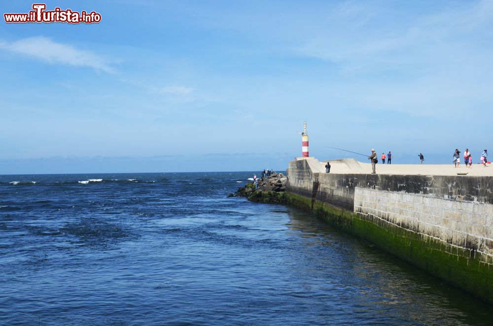 Immagine Il faro di segnalazione direzionale su un molo di Esposende con i pescatori, nord del Portogallo.
