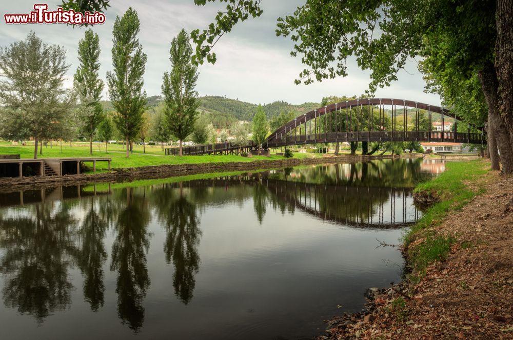 Immagine Il fiume Serta attraversato da un ponte pedonale in una giornata nuvolosa (Portogallo).