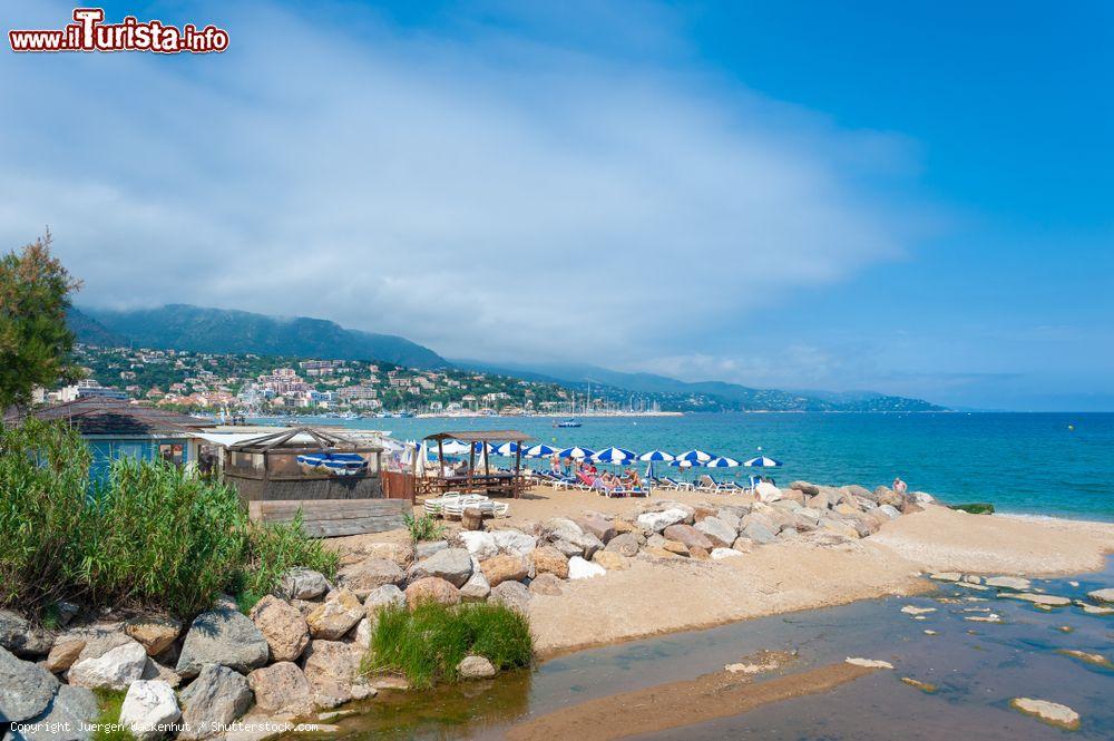 Immagine Il litorale di Le Lavandou, Francia, con ombrelloni colorati e ristoranti - © Juergen Wackenhut / Shutterstock.com