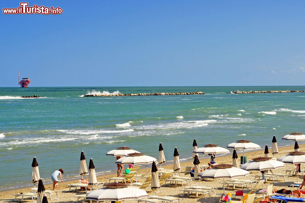 Immagine Il mare di Lido Adriano con gli scogli che proteggono la spiaggia dall'erosione. Al largo una piattaforma per l'estrazione di gas naturale
