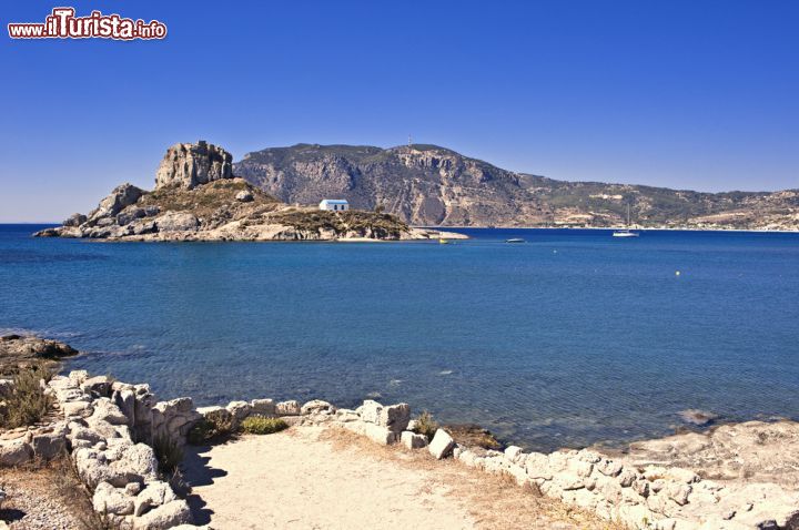 Immagine Il mare limpido di Kos, isola della Grecia: sullo sfondo l'isolotto di Kastri con la chiesetta - © Harald Lueder / Shutterstock.com