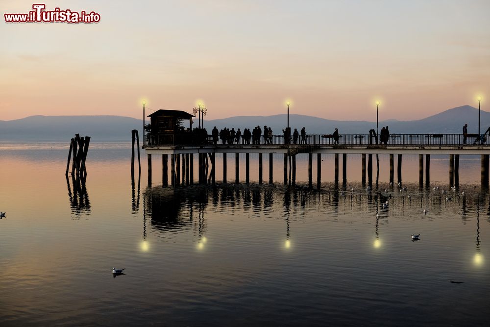 Immagine Il molo illuminato di sera al porto di Anguillara Sabazia, Lazio.