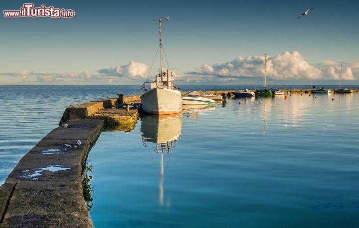 Immagine Il molo in pietra con le barche ormeggiate alla marina di Curonian Spit, Nida, Lituania - © Sergei25 / Shutterstock.com