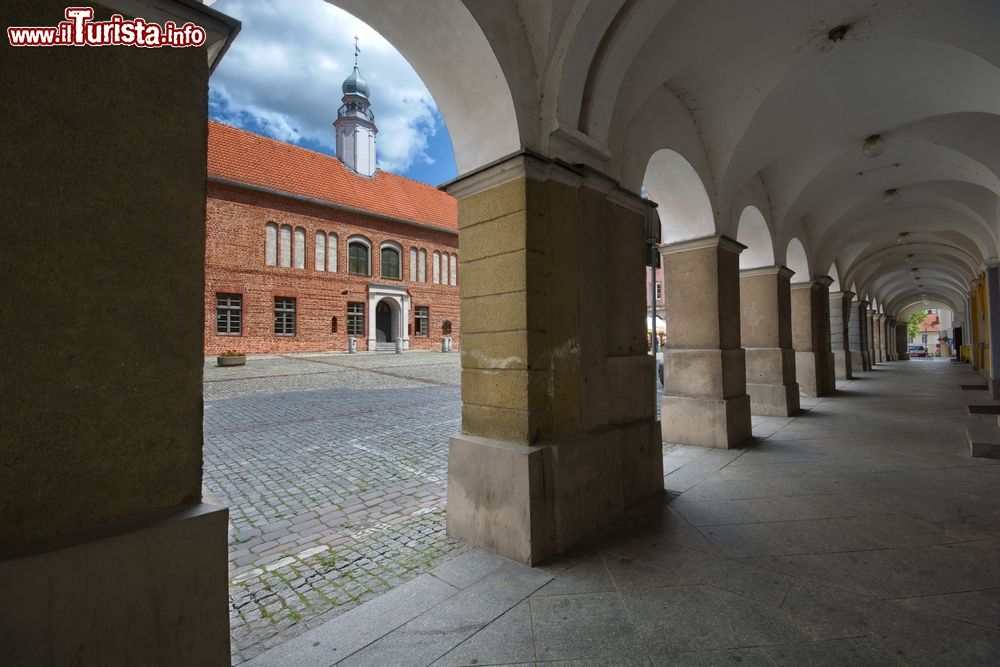 Immagine Il Palazzo Comunale gotico fotografato dal porticato di un vecchio caseggiato del centro storico di Olsztyn, Polonia.