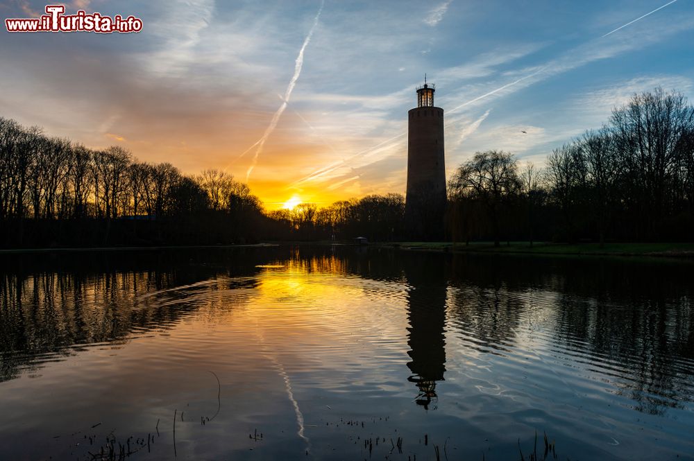 Immagine Il parco pubblico Maria Hendrika al tramonto a Ostenda, Belgio, con la torre dell'acqua. I colori del cielo si riflettono sul lago artificiale.