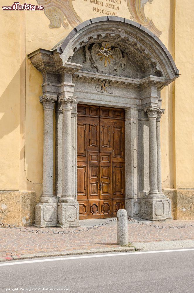 Immagine Il portale d'ingresso alla chiesa di Pinzolo, Trentino Alto Adige. Costruito in legno massiccio, è affiancato su entrambi i lati da due colonne e sormontato da una copertura con motivi decorativi  © MoLarjung / Shutterstock.com