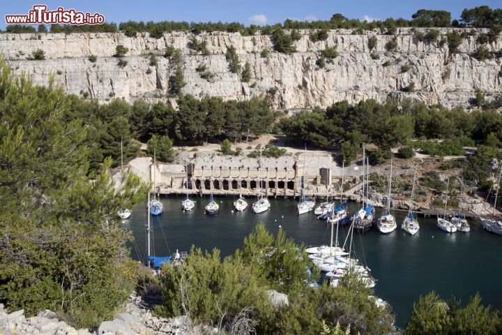 Immagine Il porto di Bandol con la costa rocciosa sullo sfondo, Francia. Uno splendido scorcio naturalistico fa da perfetta cornice al porticciolo di Bandol dove sono ormeggiate piccole imbarcazioni - © Anna Biancoloto / Shutterstock.com