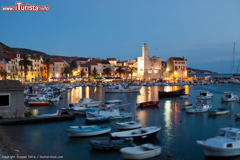 Immagine Il porto di Komiza, isola di Vis, fotografato al tramonto. Il porto è circondato da palme e case in stile veneziano costruite fra il XVI° e XVII° secolo - © Stjepan Tafra / Shutterstock.com