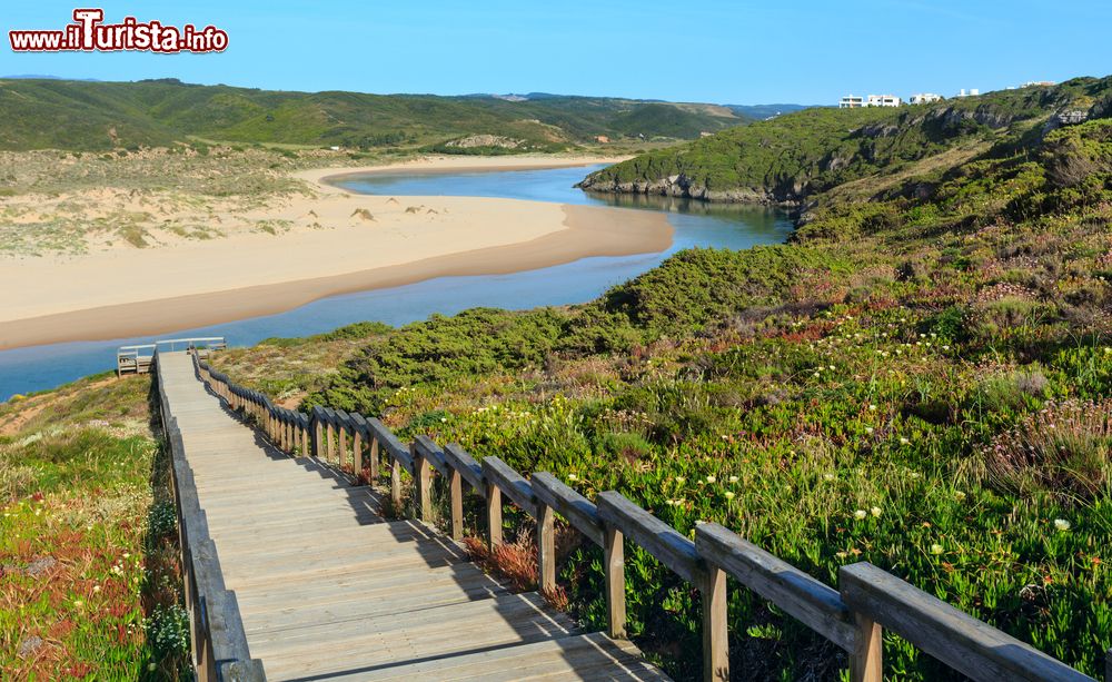 Immagine Il sentiero in legno per la spiaggia di Amoreira e il fiume Aljezur fotografati in estate, Portogallo.