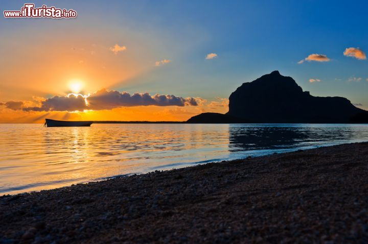 Immagine Il sole tramonta nell'oceano indiano, a Le Morne Brabant - Mauritius, e in particolare la penisola di Le Morne Brabant, la zona più selvaggia, è un paradiso tropicale che per i suoi colori, la sua bellezza e la sua natura, ha ispirato grandi poeti della storia a comporre rime su di esso. Da Baudelaire, a Mark Twain, a Joseph Conrad, che definì quest'isola come "una perla che distilla grande dolcezza sul mondo". - © shamsheed / Shutterstock.com