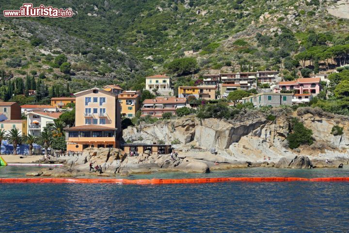 Immagine Il villaggio di Giglio Porto in Toscana: la barriera di protezione arancione era stata installata per scongiurare eventuali sversamenti di gasolio sulla costa, che potevano accadere durante le operazioni di recupero della Costa Concordia, naufragata nelle vicinanze - Italy - © trotalo / Shutterstock.com