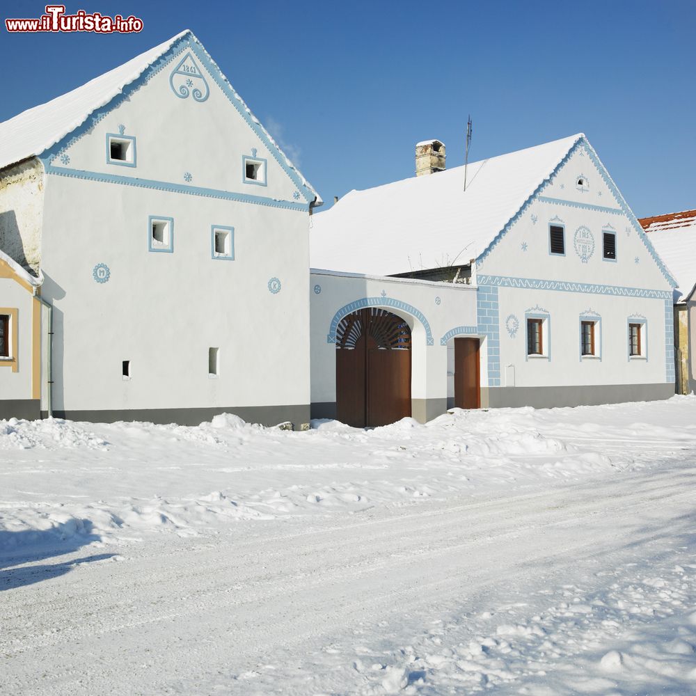 Immagine Il villaggio di Holasovice in inverno, Repubblica Ceca. Una suggestiva immagine degli edifici innevati nel cuore del paese fatto di villette, fattorie e giardini.