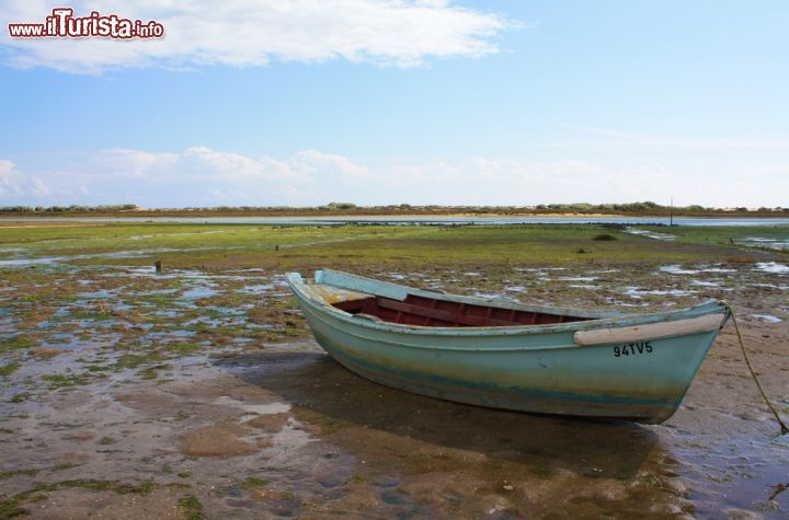 Immagine Imbarcazione in un lago dell'Algarve, Portogallo - Azzurra, come il colore dell'acqua limpida del mare, questa barca dei pescatori è ancorata in un lago dell'Algarve vicino a Cacela Velha © Brigida Soriano / Shutterstock.com