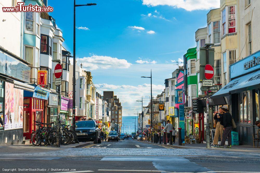 Immagine Incrocio di una strada con negozi nella città di Brighton, Inghilterra, con gente a passeggio - © ShutterStockStudio / Shutterstock.com