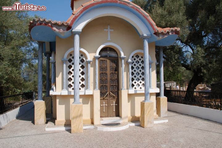 Immagine Ingresso a una chiesetta di Katomeri a Meganissi, Grecia - Un grazioso colonnato circonda questa piccola chiesetta del villaggio di Katomeri sull'isola di Meganissi. Finestre finemente decorate affiancano la porta da cui si accede al luogo di culto © David Fowler / Shutterstock.com