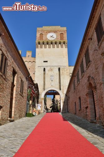 Immagine L'ingresso al castello di Gradara, Italia. Uno stretto veicolo acciottolato accompagna alla porta d'ingresso della fortezza medievale protetta da due cinte murarie, la più esterna delle quali si estende per circa 800 metri rendendo questa struttura una delle più imponenti esistenti in Italia