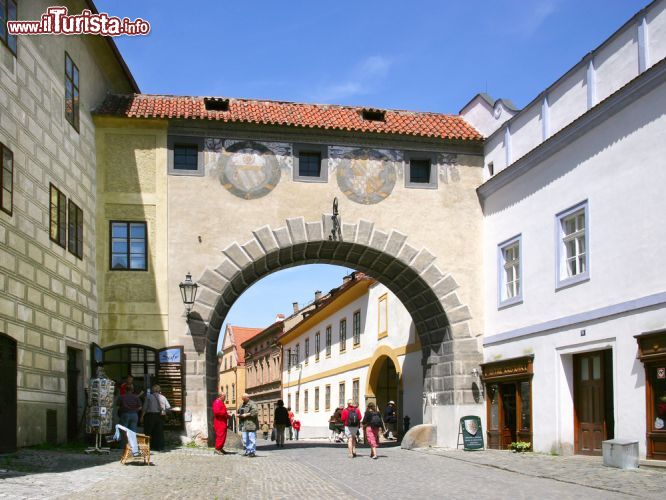 Immagine Il sole risplende sulla porta medievale che conduce al castello di Cesky Krumlov, Repubblica Ceca - questa porta di antichissima costruzione rappresenta la via d'ingresso verso il magnifico castello medievale della città. L'espediente architettonico delle porte cittadine è del resto una costante nelle città la cui costruzione risale al medioevo e questa in particolare, su cui sono evidenti le tracce di successivi restauri, è davvero suggestiva.  - © kaprik / Shutterstock.com