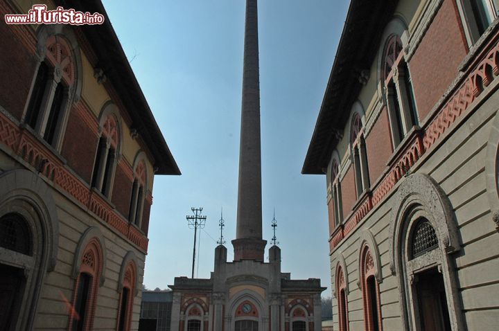 Immagine Verso l'ingresso del Cotonificio Crespi - il maestoso ingresso del cotonificio è probabilmente l'immagine più conosciuta del villaggio operaio di Crespi d'Adda. L'alta ciminiera, il cancello in stile liberty, i dettagli in cotto, creano una composizione architettonica che è chiara espressione di un'epoca industriale, in cui un imprenditore visionario ha compiuto una piccola grande impresa, realizzando una delle poche autosufficienti città operaie d'Europa.  