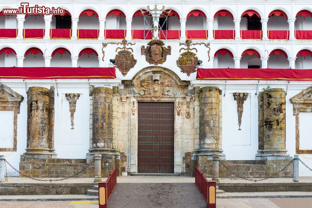 Immagine Ingresso della chiesa di Nostra Signora della Granada a Llerena, Spagna. Da notare gli stemmi e le decorazioni presenti nei pressi del portale e le arcate con i drappeggi rossi. 