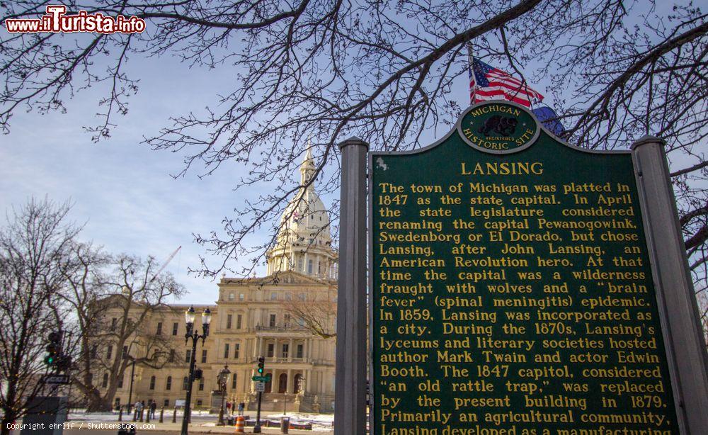 Immagine Insegna storica di fondazione della città di Lansing, Michigan (Stati Uniti d'America). Sullo sfondo il Campidoglio e la bandiera americana - © ehrlif / Shutterstock.com