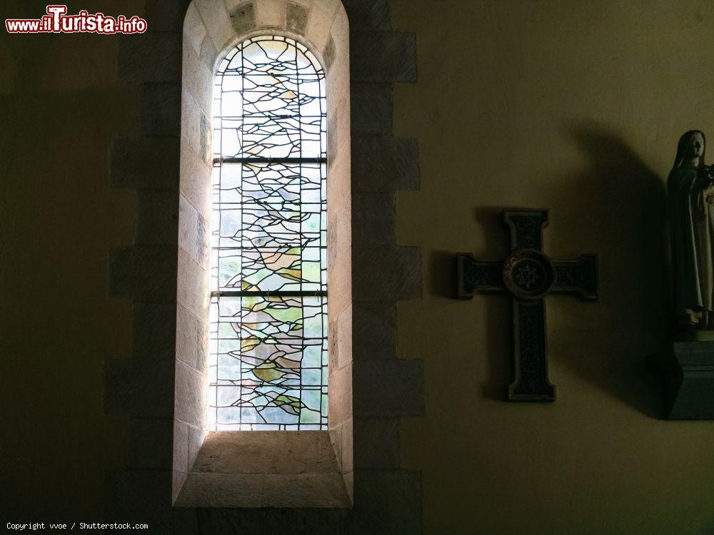 Immagine Interno dell'oratorio carolingio di Germigny-des-Pres, Francia, con una vetrata decorata e un crocifisso appeso al muro - © vvoe / Shutterstock.com