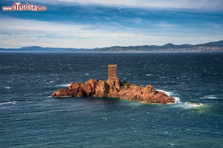 Immagine Isola d'Oro nei pressi di Cap Dramont a Saint Raphael, Francia - Questo piccolo isolotto roccioso di porfido si trova circa 300 metri a sud di Saint-Raphael nel dipartimento del Var, sulla costa francese. Lambita dalle acque del Mediterraneo, ques'isola rossa lunga 190 metri e larga 90 fa parte delle Hyères. Nell'agosto del 1944 le forze armate americane sbarcarono proprio qui durante la liberazione della Francia meridionale dai tedeschi. L'ile d'Or, di proprietà dei discendenti di Francois Bureau, ufficiale della Marina francese che la acquisto nel 1961, è inaccessibile agli estranei: d'inverno la sua torre è abitata solo dal custode © Jaka Zvan / Shutterstock.com