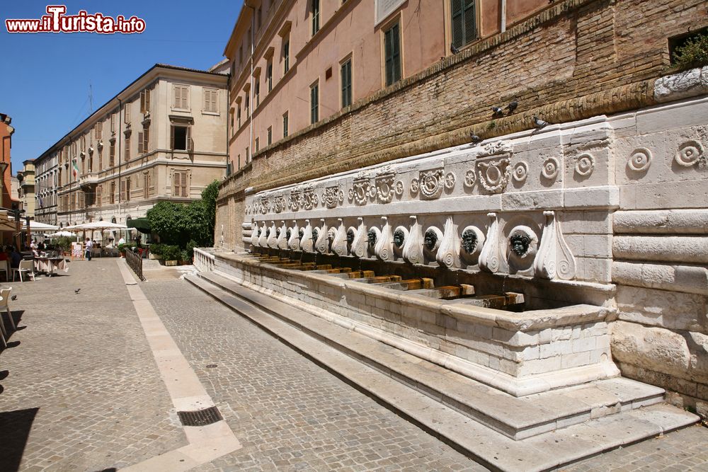 Immagine La bella "Fontana delle Tredici Cannelle" a Ancona, Marche. Realizzata in pietra bianca del Conero e bronzo, questa fontana, nota anche come "del Calamo", si trova in corso Mazzini. Secondo la tradizione, chi desidera ritornare in città deve bere l'acqua che vi sgorga.