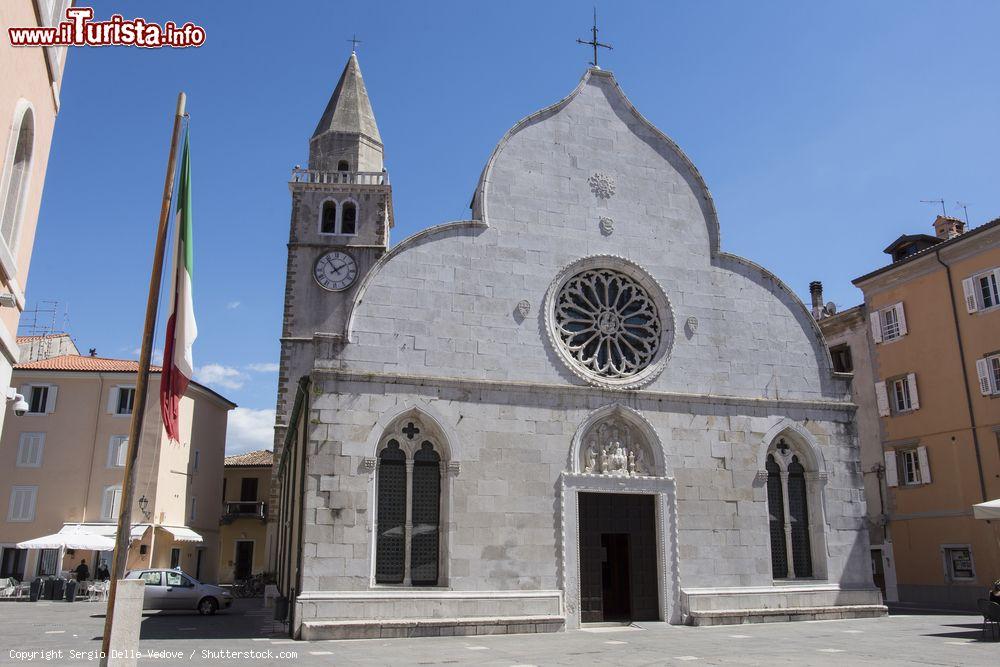 Immagine La cattedrale di Muggia, Friuli Venezia Giulia. Dedicato ai santi Giovanni e Paolo, il duomo cittadino venne consacrato nel dicembre del 1263. La facciata si presenta in pietra bianca con rilievi nella lunetta del portale - © Sergio Delle Vedove / Shutterstock.com