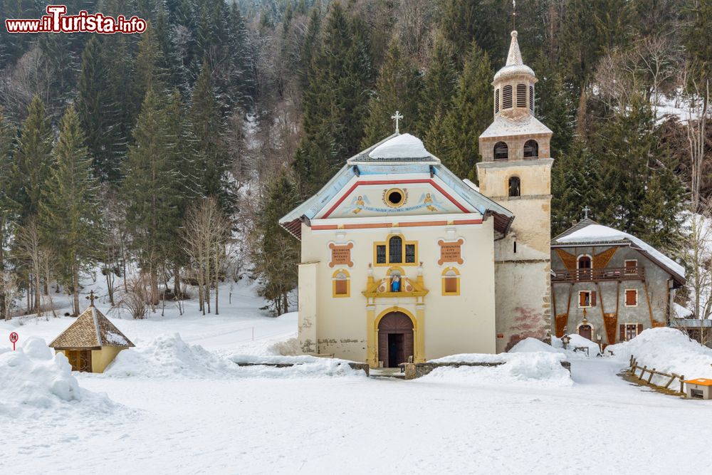 Immagine La chiesa di Notre Dame de la Gorge a Les Contamines-Montjoie, Alpi francesi, in inverno con la neve. Qui ogni anno, il 15 di Agosto, si svolge un pellegrinaggio di fedeli.