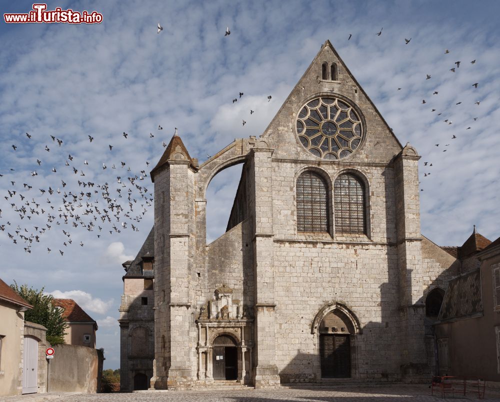 Immagine La chiesa di Saint-Aignan a Chartres con stormi di uccelli in volo, Francia. Situata non lontano dalla cattedrale cittadina, questa bella chiesa ricca di vetrate e pitture venne costruita nel cuore della città nel V° secolo.