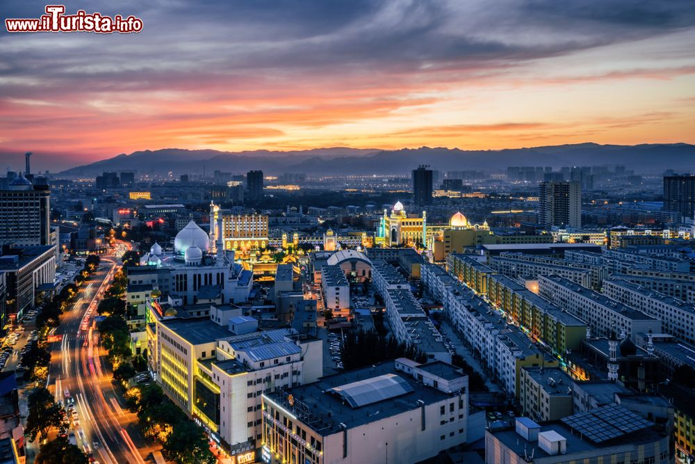 Immagine La città di Hohhot, Mongolia Interna, con edifici e palazzi fotografata di notte.