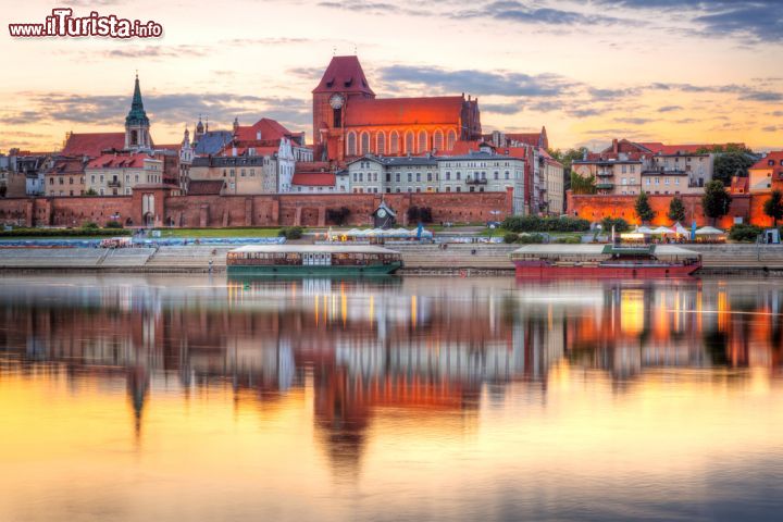 Immagine La città di Torun si rispecchia nel fiume Vistola, Polonia. Una bella immagine scattata al tramonto di questa cittadina polacca, importante centro industriale nel settore chimico. E' situata sulle rive del fiume Vistola, il più lungo della Polonia: nasce dai monti Beschidi Occidentali in Slesia e sfocia nella baia di Danzica, nel Mar Baltico - © Patryk Kosmider / Shutterstock.com