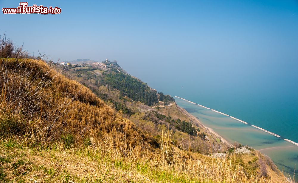 Immagine La costa lungo Monte San Bartolo nei pressi di Pesaro: sullo sfondo il grazioso borgo medievale di Fiorenzuola di Focara (Marche).