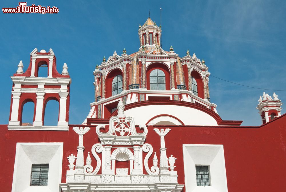 Immagine La cupola della chiesa di San Domenico a Puebla, Messico, con i suoi particolari architettonici che risaltano sulla facciata rossa.