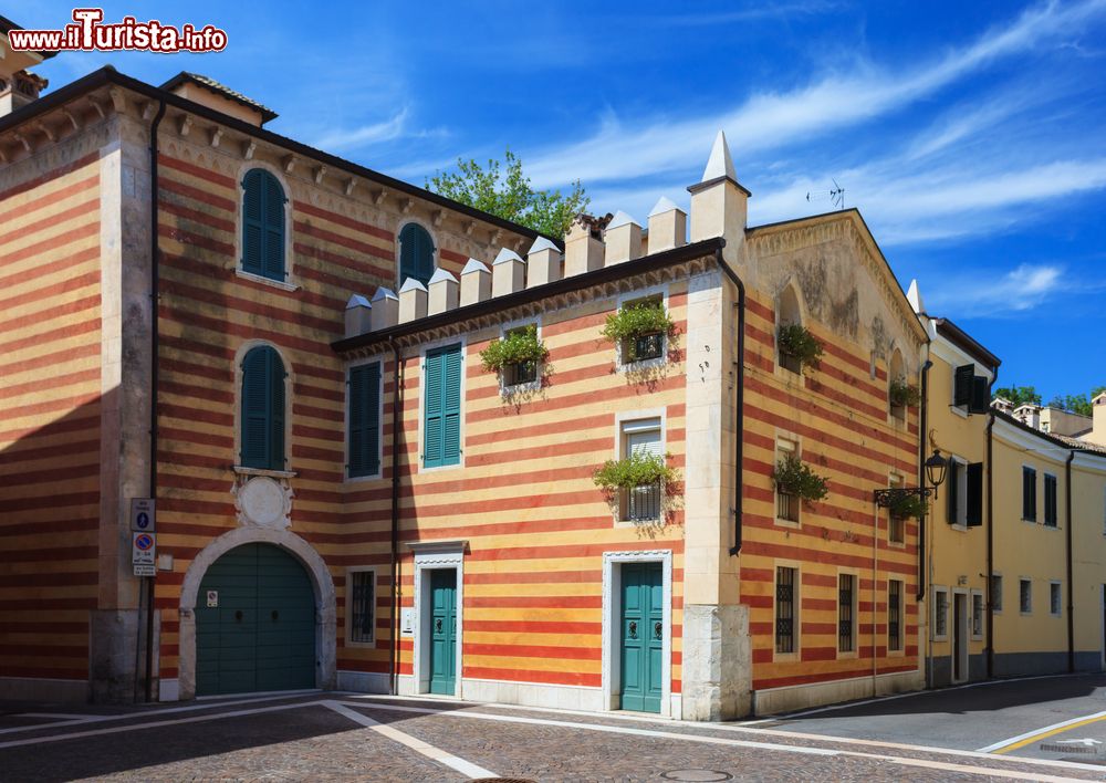 Immagine La facciata a righe gialle e rosse di un palazzo a Bardolino, provincia di Verona, Veneto. Si tratta di un tipico esempio di architettura veneta.