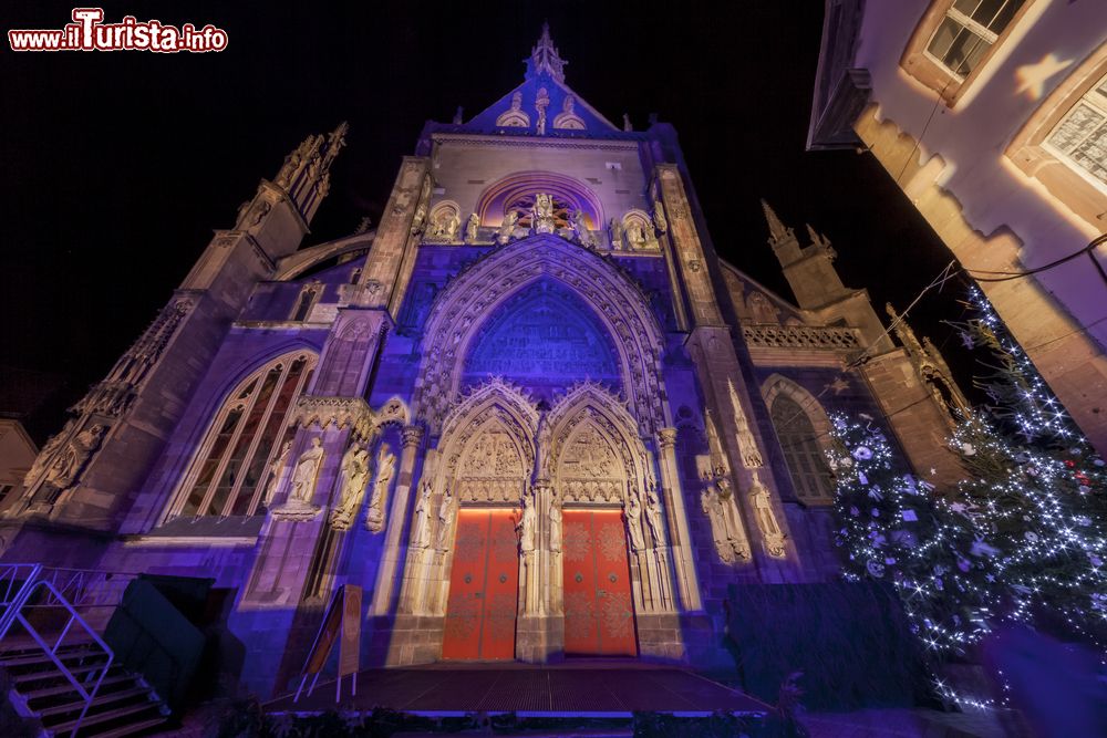 Immagine La facciata della chiesa di San Teobaldo decorata per Natale e illuminata di notte, Alsazia, Francia.