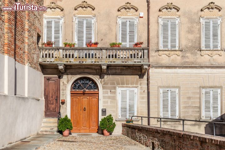 Immagine La facciata di un tipico palazzo italiano a La Morra, Cuneo, Piemonte. A impreziosirlo ci sono i fiori sul balcone e il portone d'ingresso in legno