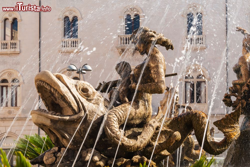 Immagine La fontana di Diana in piazza Archimede a Siracusa, Sicilia. Opera di Giulio Moschetti, questa scultura monumentale risale al 1907. Rivolta a sud, questa fontana mette in risalto la figura di Diana con arco e cane.