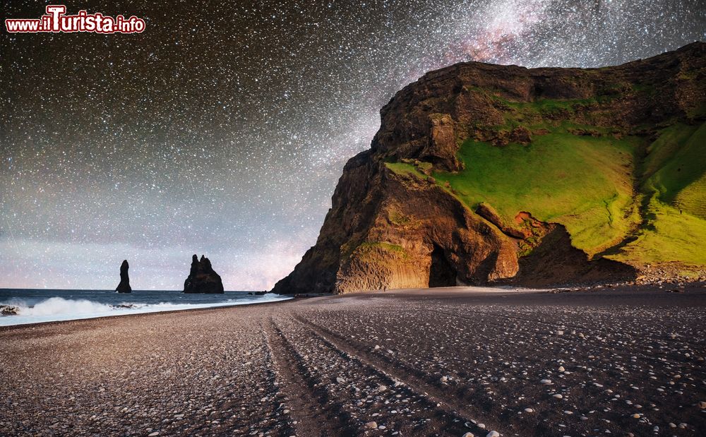 Immagine La formazione rocciosa Reynisdrangar sulla spiaggia nera di Reynisfjara, Islanda. Nei pressi di Vik i Myrdal, i faraglioni di Reynisdrangar si trovano a breve distanza dalla costa e sono scogli di roccia basaltica, resti di una costa più ampia erosa con il passare del tempo dall'Atlantico. Nell'immagine, una suggestiva stellata con la Via Lattea.