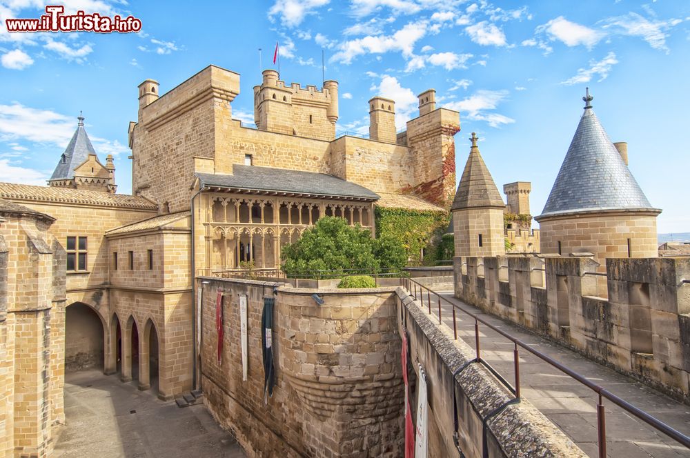 Immagine La fortezza di Olite, Spagna, con le nubi in cielo. Circondata da mura armate da 15 torri, al suo interno ospita splendidi giardini pensili.