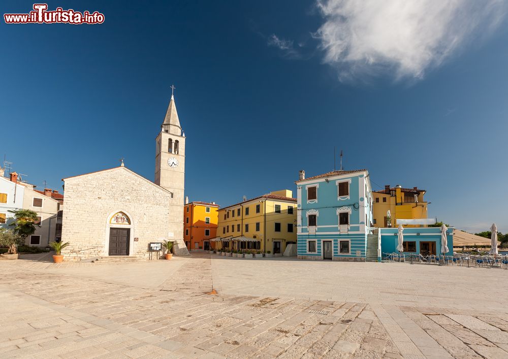 Immagine La grande piazza di Fazana con la chiesa dei Santi Cosma e Damiano, Croazia. Dedicato ai santi protettori del villaggio di pescatori istriano, l'edificio religioso ospita un crocifisso gotico e un organo del 1858.