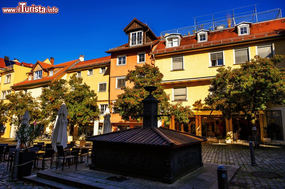 Immagine La graziosa Paradise Square a Lindau in autunno con fontana, alberi e vecchi edifici, Germania.