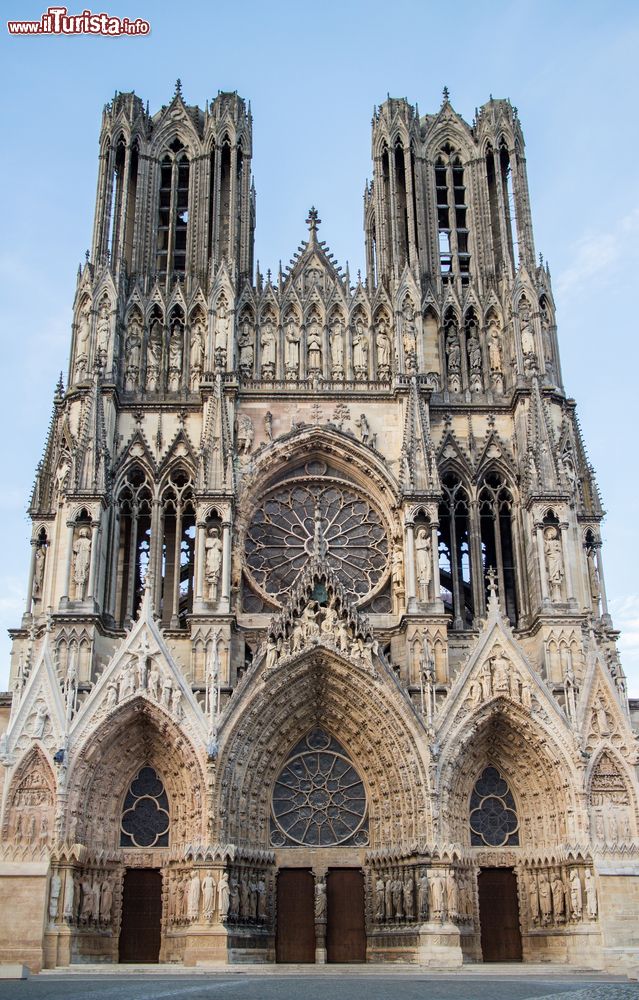 Immagine La maestosa facciata di Notre-Dame di Reims, Francia. I tre portali d'ingresso sono ricoperti di statue di grandi e piccole dimensioni; il portale centrale è inoltre sormontato da un grande rosone.