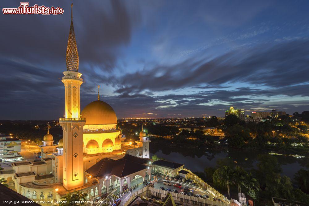 Immagine La moschea Masjid Bandar Diraja Klang di sera, Selangor, Malesia. Situata sulle rive del fiume Klang, questa bella moschea mostra influenze mediorientali mescolate a elementi di architettura più moderna. Interamente realizzata in cemento, è caratterizzata da una cupola color gialla e da un puntatore che può essere visto da chilometri di distanza - © muhamad mizan bin ngateni / Shutterstock.com