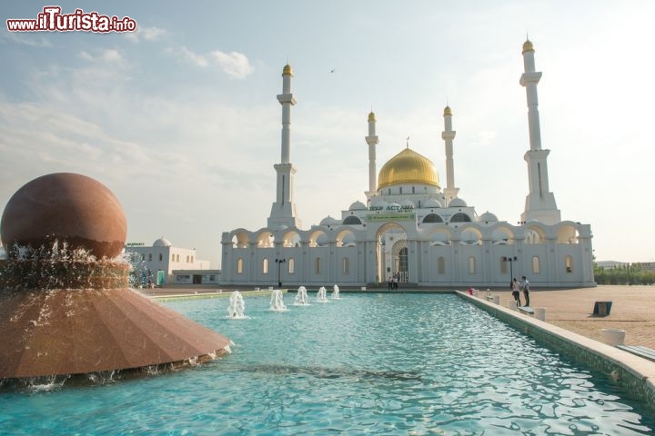 Immagine La moschea Nur Gasyr a Astana, Kazakistan - Se con il calar delle luci uno dei luoghi di culto simbolo della moderna capitale del Kazakistan si riveste di un'atmosfera suggestiva, di giorno questo splendido esempio di edificio religioso non si presenta certo meno interessante agli occhi di fedeli e turisti. In questa immagine, l'imponente fontana d'acqua che accompagna all'ingresso della moschea © Nutexzles / Shutterstock.com