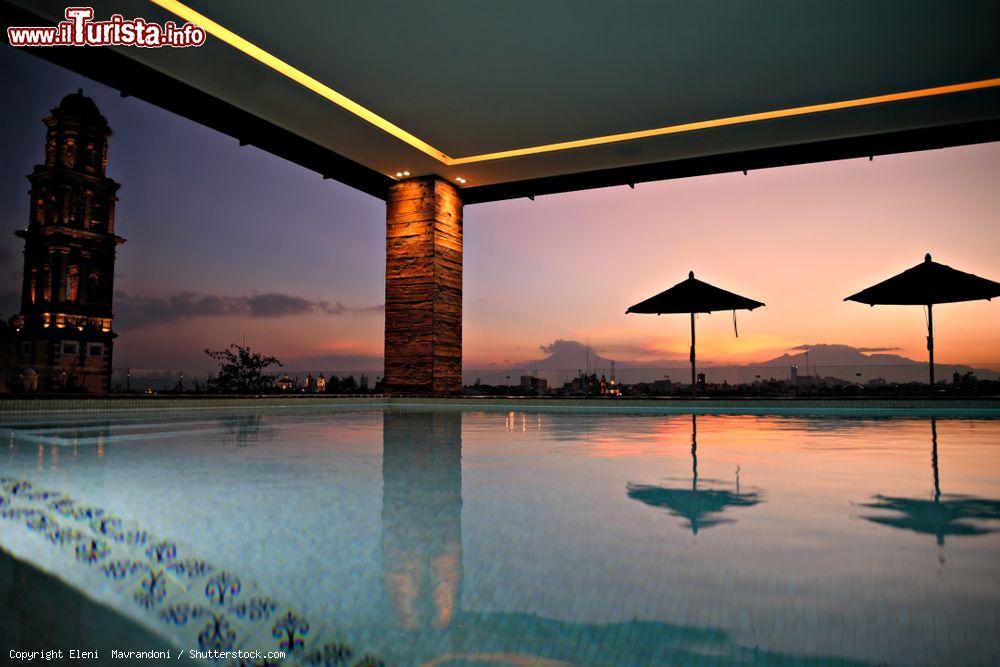 Immagine La piscina del Rosewood Hotel di Puebla con gli ombrelloni riflessi nell'acqua e, da un lato, la torre campanaria di San Francesco (Messico) - © Eleni Mavrandoni / Shutterstock.com