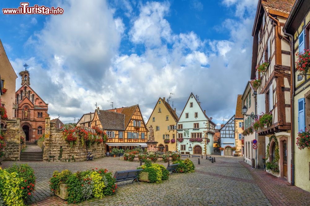 Immagine La pittoresca piazza di Eguisheim con la chiesa e la fontana con statua di Leone IX°, Alsazia (Francia).