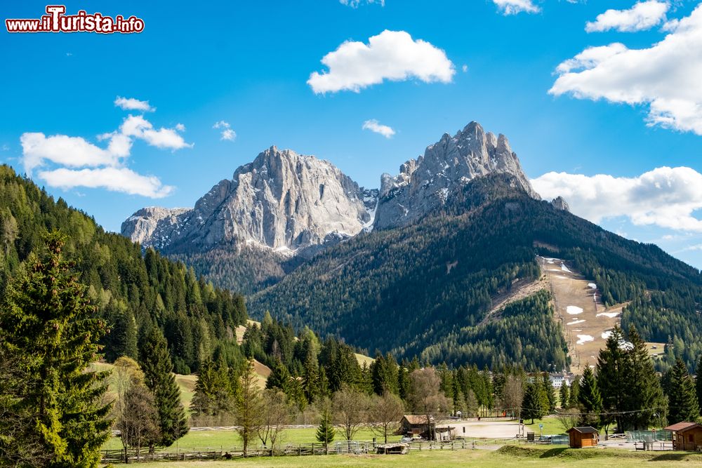 Immagine La primavera nel villaggio di Pozza di Fassa, Trentino Alto Adige. Le vette dei monti ancora innevate lasciano spazio al verde rigoglioso della vegetazione che, dopo l'inverno, torna a splendere con i suoi colori e profumi.